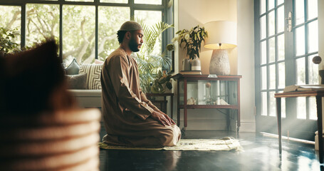 Fototapeta premium Islam, prayer and religion with man in home for ramadan kareem, spiritual and worship. Floor, faith and eid Mubarak with Muslim person and salah in living room for holy month, Allah praise and dua