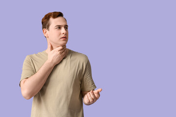Young man with sore throat on lilac background