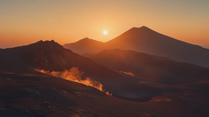 Mountainous landscape scene with a bright sun at sunset or sunrise