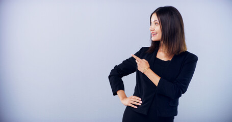Business, woman and pointing direction in studio with announcement, promotion and sign up. Female...