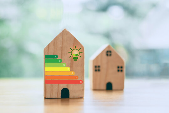 For house energy efficiency, eco home renovation save cost. Low consumption ecological house, Sustainable Development Concept, house with energy efficiency scale on blurred background