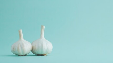 Two fresh garlic bulbs displayed on a minimalist background, showcasing their natural texture and form.
