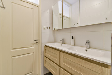 A sleek and contemporary bathroom showcasing elegant fixtures and ample storage space. The design combines functionality with modern aesthetics, creating a serene atmosphere.