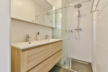 Stylish bathroom featuring a glass shower, modern fixtures, and sleek cabinetry, perfect for contemporary home aesthetics.