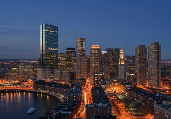 Fototapeta premium Boston skyline at dusk with illuminated skyscrapers and waterfront view