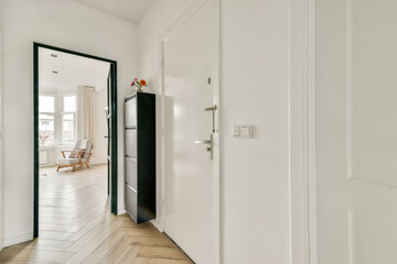 A serene entrance hallway showcasing beautiful wooden flooring and a glimpse of a bright room beyond, creating a warm and welcoming atmosphere.
