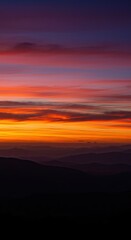 Fototapeta premium Majestic mountain landscape at sunset with vibrant sky and silhouetted peaks