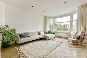 A stylish modern living room featuring a neutral color palette, a cozy sofa, and a touch of greenery that brightens the space. Ideal for relaxation and comfort.