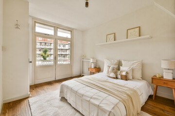 A serene bedroom featuring a light color palette, wooden flooring, and minimalist furniture, creating a calming atmosphere perfect for relaxation.