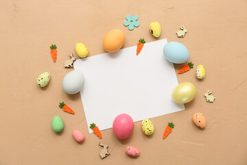 Blank card with Easter eggs, mini carrots and bunnies on beige background