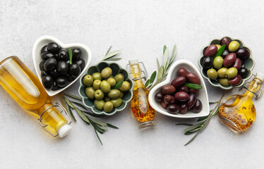 Black, green and kalamata olives with olive oil and olive branches creating a mediterranean...