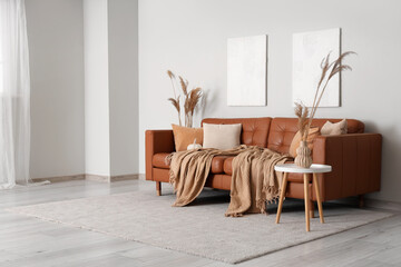 Comfortable sofa and coffee table with pampas grass in vase in interior of living room