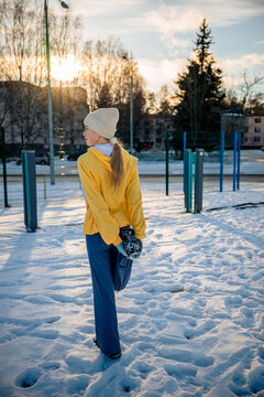 Woman stretching her leg on outdoor in winter. Fitness and healthy