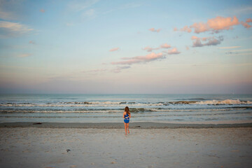 Obraz premium Young girl at Sunset beach