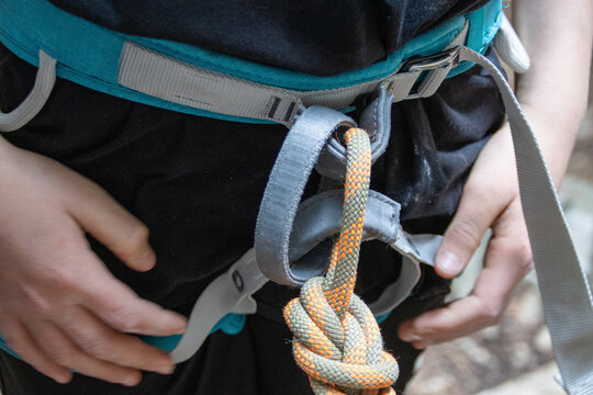 Close-up of rock climbing harness with rope tied in a secure knot.