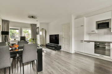A sleek and contemporary dining area featuring a glass table, stylish chairs, and an open kitchen layout that enhances the modern living experience.
