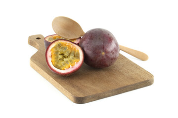 Fresh passion fruits and wooden spoon resting on cutting board