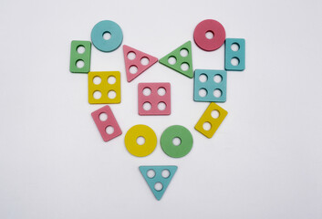 A heart shape created from vibrant geometric pieces, displayed on a clean white background. This...