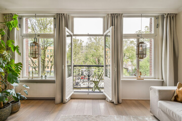 A serene modern living room featuring large windows that invite natural light and showcase a view...