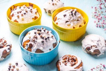 Cupcakes and muffins or Easter cakes poured with white icing on a light blue table. Space for text. View from above. Flat layout