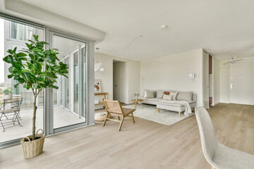 A stylish, modern living room featuring minimalistic furniture, large windows, and a touch of greenery, creating a serene and inviting atmosphere.