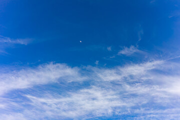 Beautiful clear sky with wispy clouds and a crescent moon
