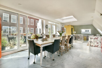 Bright and airy interior featuring a stylish dining area with elegant furniture and large windows overlooking a vibrant outdoor space.