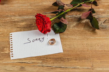 Broken engagement with a rose and a note conveying regret and sorrow