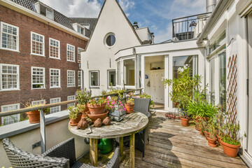 A serene balcony features a mix of lush plants and flowers, complemented by cozy seating...