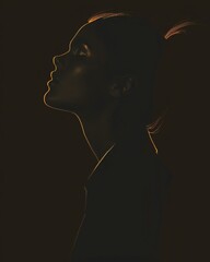 Silhouette Portrait of Woman with Golden Light Outline on Dark Background