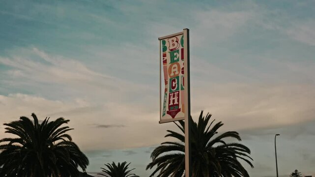 Cinematic Beach Sign - Pastel Sunset, Palm Trees, Walking Handheld 4K 24fps