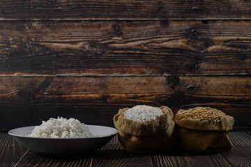 Different Types of Rice in Jute Bags on Wooden Surface Background