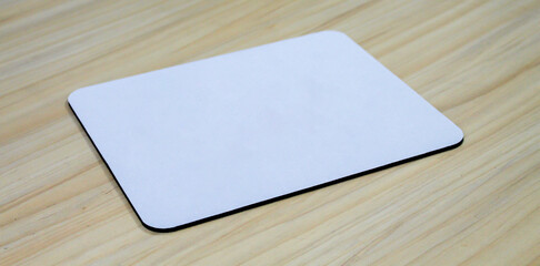 blank square mouse pad on wooden table