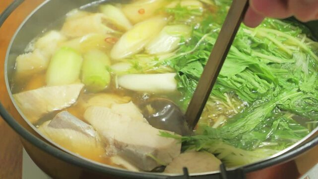Trying to eat yellowtail cooked in a pot.