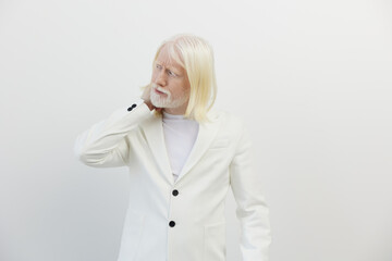 elderly man in a white suit, standing against a light background, looking contemplative, exhibiting...
