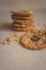 Round dried apple slice with crushed nuts on top. Healthy homemade fruit chips with nuts on light background. Organic vegetarian snack, diet dessert, close-up of natural sweet