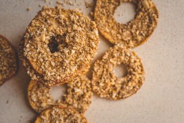 Stack of dried apple slices with crushed nuts on top. Healthy homemade fruit chips with nuts on light background. Natural organic snack, vegetarian food, diet dessert, close-up