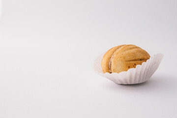 One nut-shaped cookie with condensed milk filling in a paper cup on white background. Traditional...