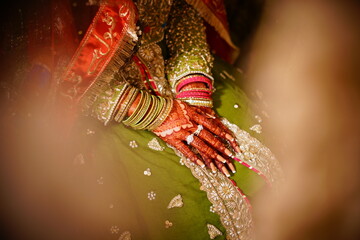 Green embodied bridal dress, bangles, rings, henna on hands, nail paint
