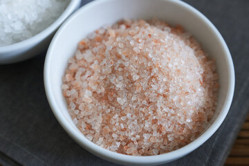 Himalayan pink salt in a bowl on a wooden table.
