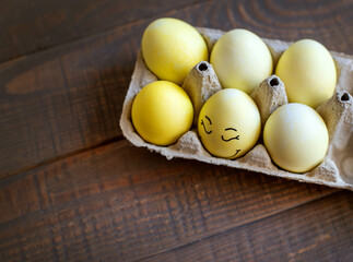 Decorative Easter egg and mimosa wreath on wooden background. Top view, space for text.