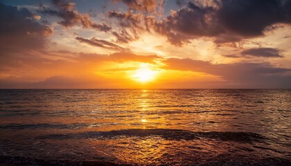 Obraz premium A breathtaking sunset over the ocean, with dramatic golden hues reflecting on the water, creating a peaceful and relaxing tropical escape.