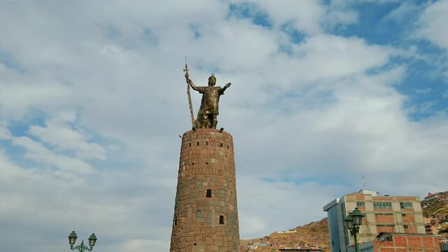 Low angle view of the famous Inca Pachacutec Monument in Cusco, at Ovalo de Pachacutec with overcast sky. cinematic shot, pan left