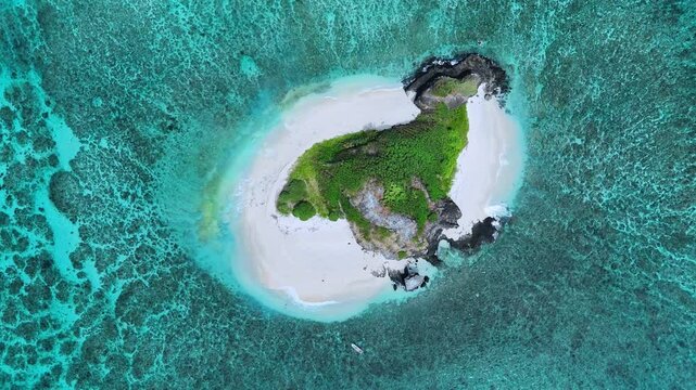 Aerial drone footage captures Fiji&rsquo;s Sacred Island, shaped like a dodo bird, surrounded by turquoise waters. The video showcases white beaches, monumental coral reefs, and lush tropical landscapes.