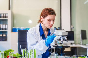 Middle-aged female laboratory worker wearing blue gloves conducts lab test on food ingredients...