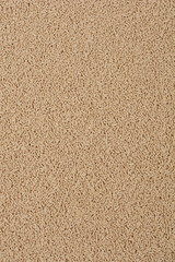 A close-up, top-down shot of dry yeast granules, displaying a consistent beige color and fine texture