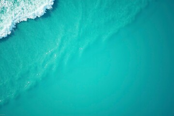 Turquoise ocean waves from above, a serene seascape of calm and beauty.