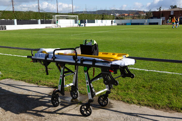 An ambulance stretcher for first aid prepared on a football field © casavella