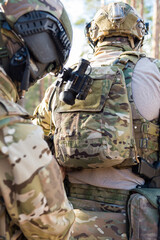 Fototapeta premium Soldiers in the forest. Military men in camouflage with weapons.