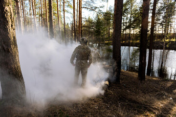 Soldiers in the forest. Military men in camouflage with weapons.